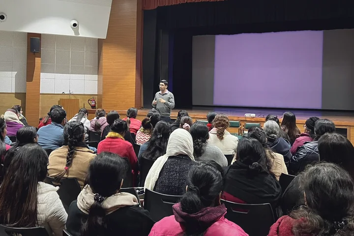 Dr. Jatin Tarwani speaking to a large audience in an auditorium