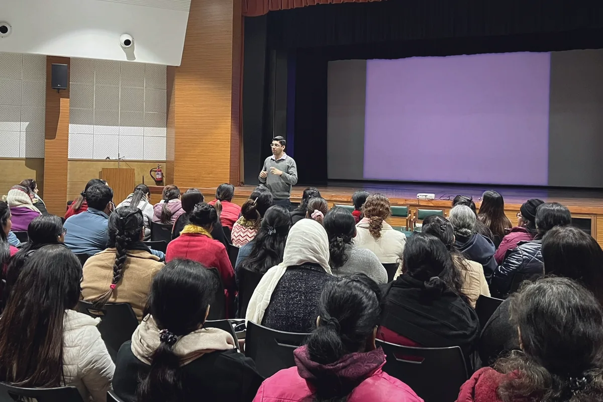 Dr. Jatin Tarwani giving a talk on mental health to a large audience in an auditorium